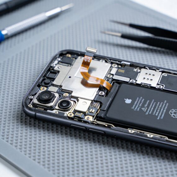 Smartphone with back cover removed showing internal battery and circuit board