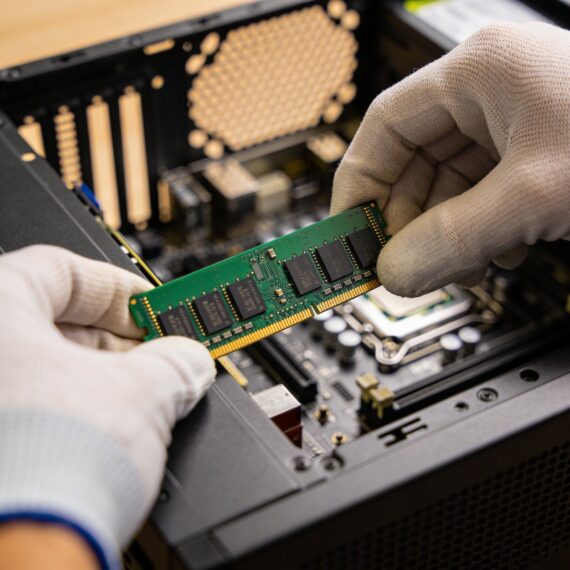 Technician hands removing RAM module from desktop computer motherboard